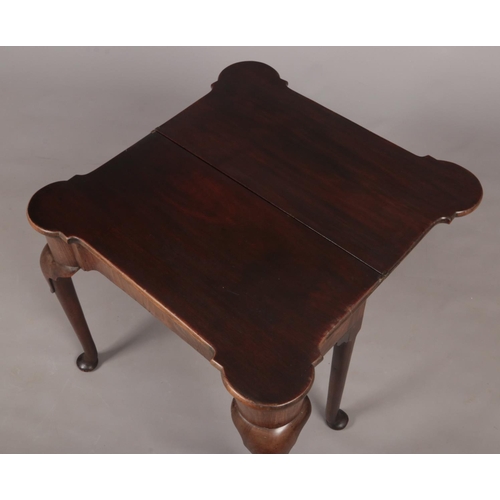 289 - A George II mahogany fold over tea table. Raised on plain cabriole supports terminating on pad feet,... 