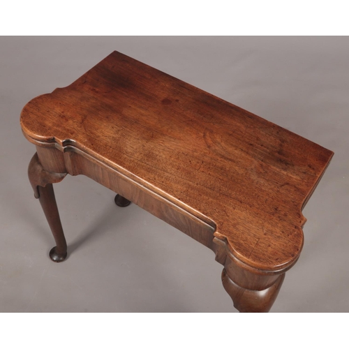 289 - A George II mahogany fold over tea table. Raised on plain cabriole supports terminating on pad feet,... 