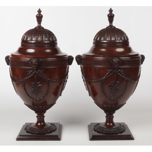 77 - A pair of Neo-Classical style mahogany fitted knife boxes of urn form. With carved ram masks and hus... 