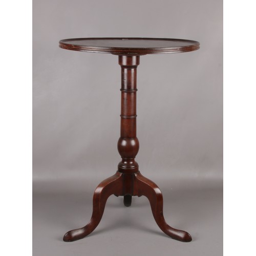 284 - A George III mahogany dish topped tripod wine table. Raised on a gun barrel column over three cabrio... 