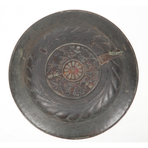 78 - A 17th century brass alms dish. Embossed with a rosette centre under a gadrooned well and with a pun... 