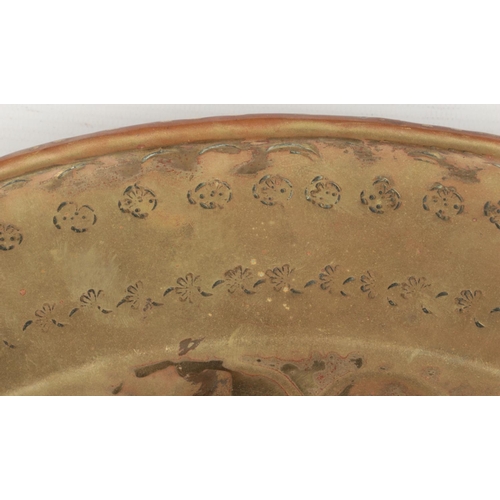 78 - A 17th century brass alms dish. Embossed with a rosette centre under a gadrooned well and with a pun... 