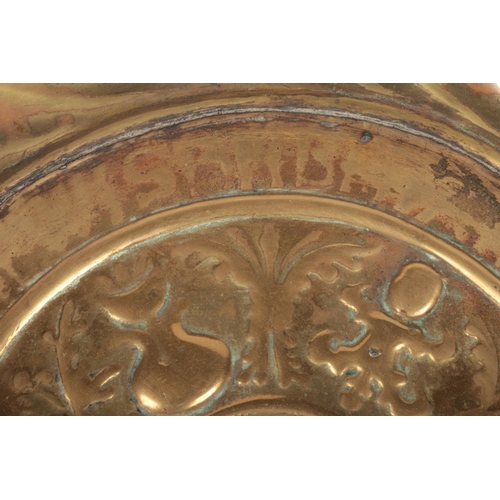 78 - A 17th century brass alms dish. Embossed with a rosette centre under a gadrooned well and with a pun... 