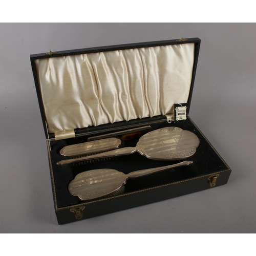 314 - A four piece silver backed dressing table set with engine turned and engraved decoration comprising ... 