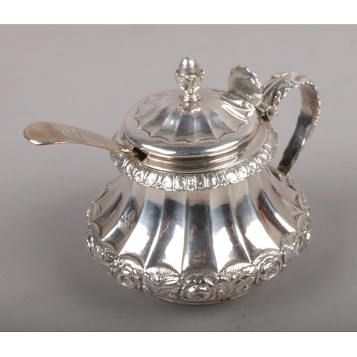 304 - A George IV silver mustard pot with acorn finial and acanthus leaf handle and shell motif thumbpiece... 