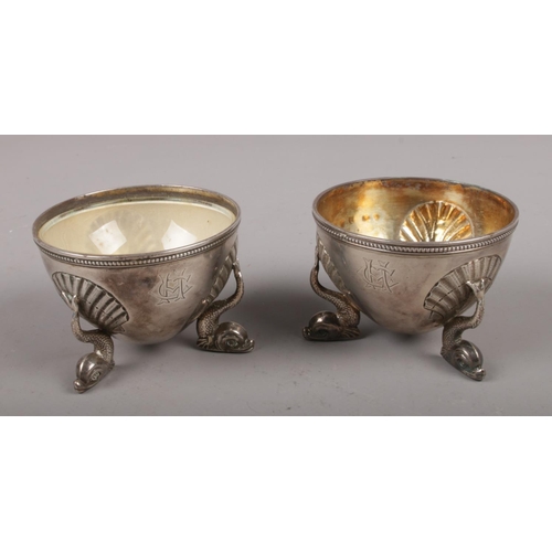 306 - A pair of Victorian silver salt cellars raised on three dolphin supports, assayed Birmingham 1862 by... 