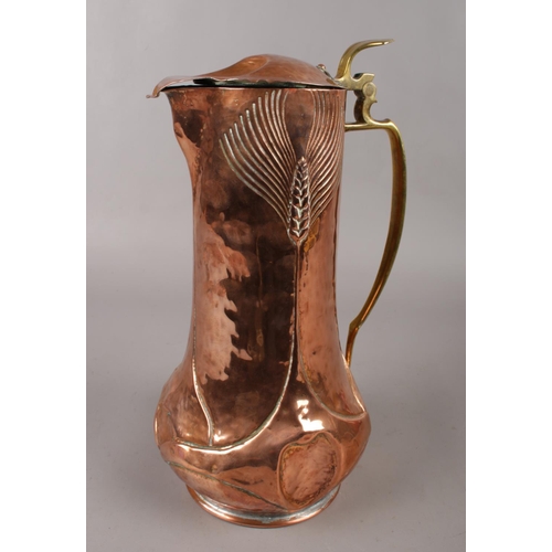 104 - A Newlyn style Arts & Crafts copper jug with brass handle and hinged lid. (Height 32cm).