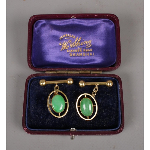 298 - A cased pair of Chinese 18ct gold cuff links with ovoid jadette tablet. 7.34g.