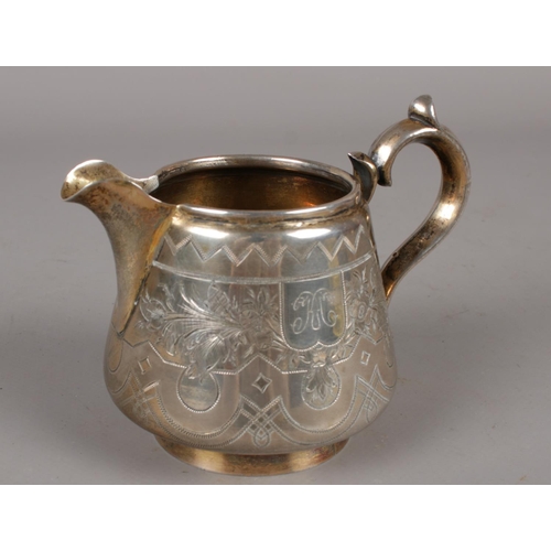 320 - A Russian silver cream jug with double scrolled handle and gilt interior. 130g.