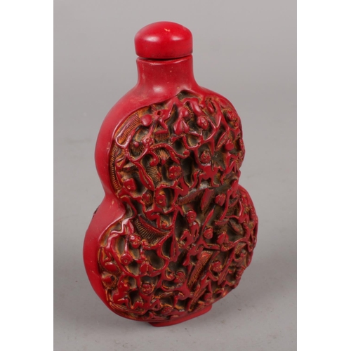 324 - A oriental cinnabar snuff bottle and stopper.