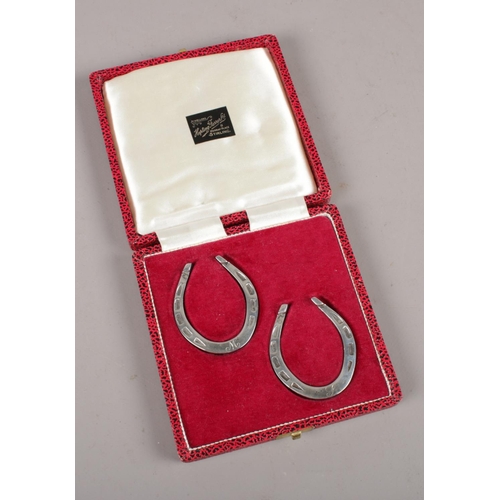 335 - A boxed pair of silver miniature horse shoes, assayed Sheffield 1975 by Francis Howard Ltd.