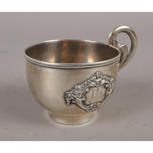 336 - A Russian silver vodka cup with beaded rim and scrolling handle with applied carouche inscribed BR, ... 