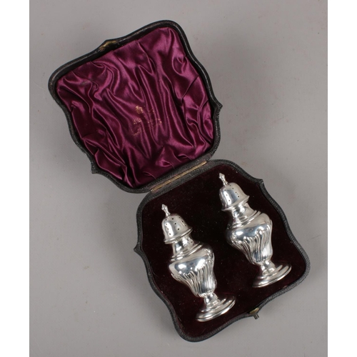 341 - A cased pair of Victorian silver pepperettes, assayed Birmingham 1876. (72g).