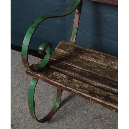 363 - A vintage wood and iron garden bench with scrolling supports. (Length 187cm).