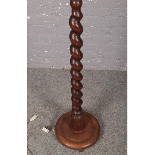 377 - An oak turned floor lamp stand with circular base and glass up shade. Height 140cm.