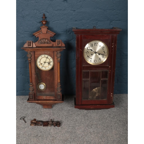 386 - Two wooden wall mounted pendulum clocks, comprising of a Pendulum clock which is decorated with a sh... 