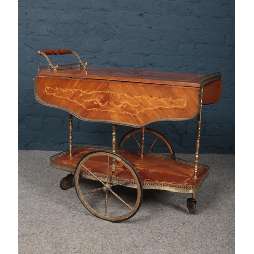 387 - A serving trolley made from brass with inlaid wooden flower design. The bottom and top tray appear t... 