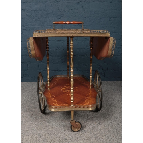 387 - A serving trolley made from brass with inlaid wooden flower design. The bottom and top tray appear t... 