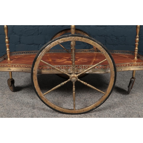 387 - A serving trolley made from brass with inlaid wooden flower design. The bottom and top tray appear t... 