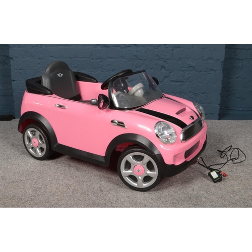 388 - A child's electric pink Mini Cooper S car together with charging plug.