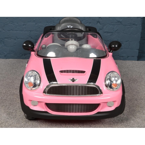 388 - A child's electric pink Mini Cooper S car together with charging plug.