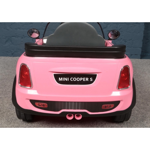 388 - A child's electric pink Mini Cooper S car together with charging plug.