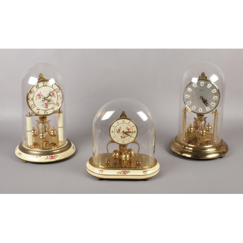 91 - Three Kern Lancel Paris brass torsion clocks, under glass domes