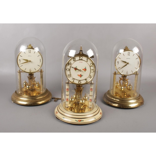 95 - Three brass torsion clocks, under glass domes, Bentima, Kundo examples