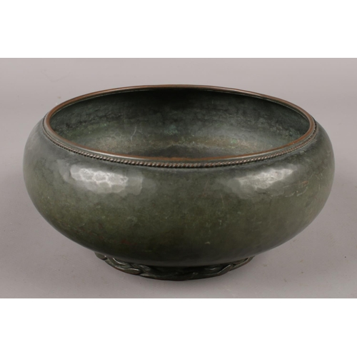 97 - An Arts & Crafts copper bowl raised on rope twist foot, stamped Dryad, Lester to base.