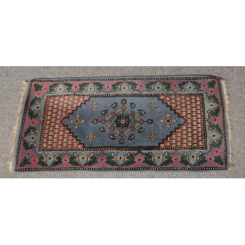 414 - A Chinese blue ground wool runner. (144cm x 72cm).