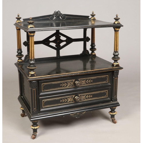 445 - A Victorian ebonized and parcel gilt two tier dumb waiter. With reeded column supports, two drawers ... 