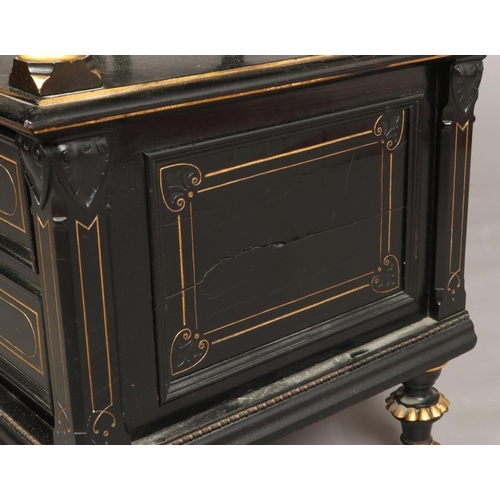 445 - A Victorian ebonized and parcel gilt two tier dumb waiter. With reeded column supports, two drawers ... 