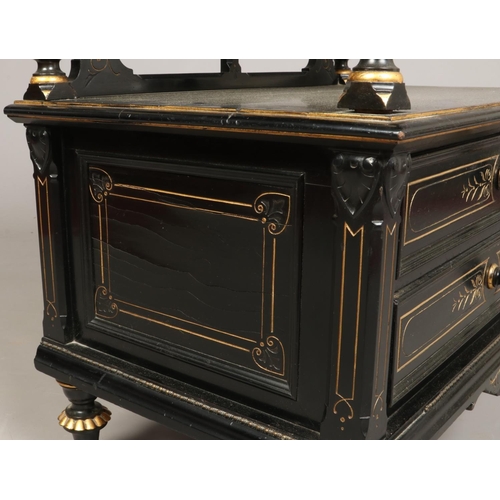 445 - A Victorian ebonized and parcel gilt two tier dumb waiter. With reeded column supports, two drawers ... 