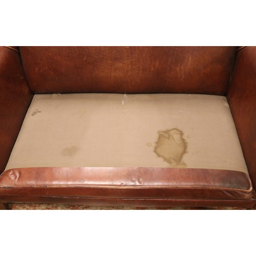 438 - A brown leather two seater sofa, with Liberty style cushions.