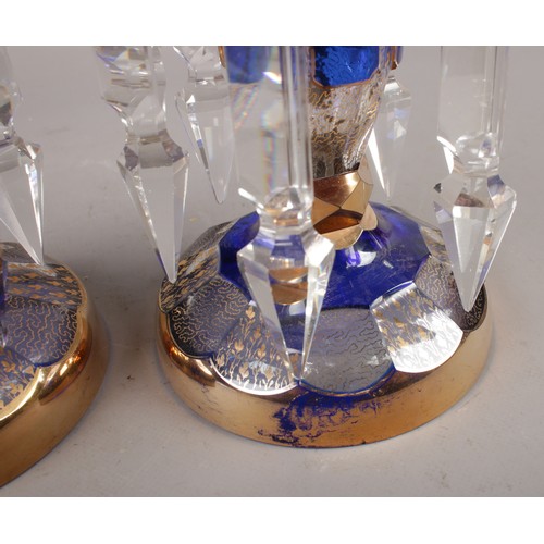 330 - A pair of clear glass lustres, with Bristol blue panels and gilt decoration, along with matching bow... 