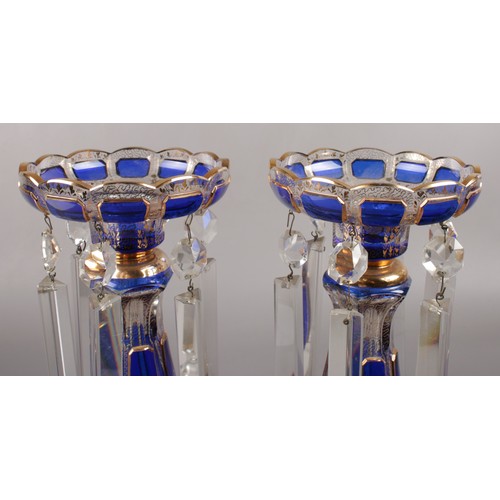 330 - A pair of clear glass lustres, with Bristol blue panels and gilt decoration, along with matching bow... 