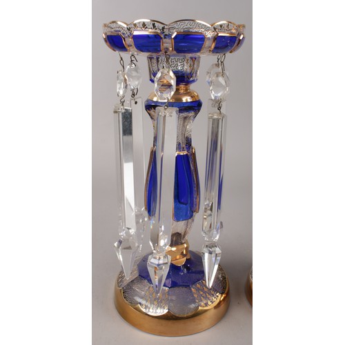 330 - A pair of clear glass lustres, with Bristol blue panels and gilt decoration, along with matching bow... 