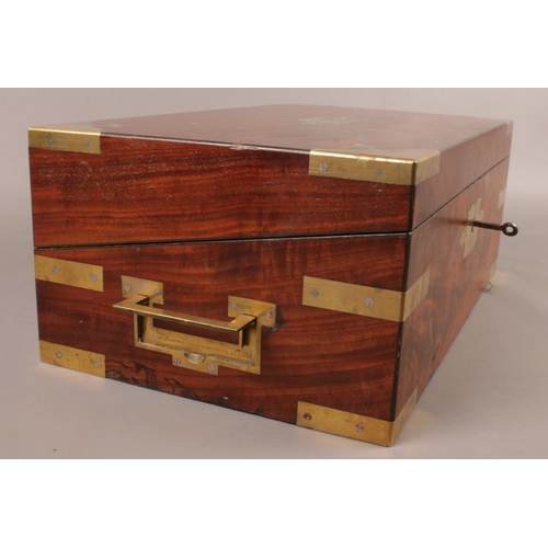 141 - A Victorian Mahogany campaign writing slope, with brass mounts to corners and straps and two handles... 