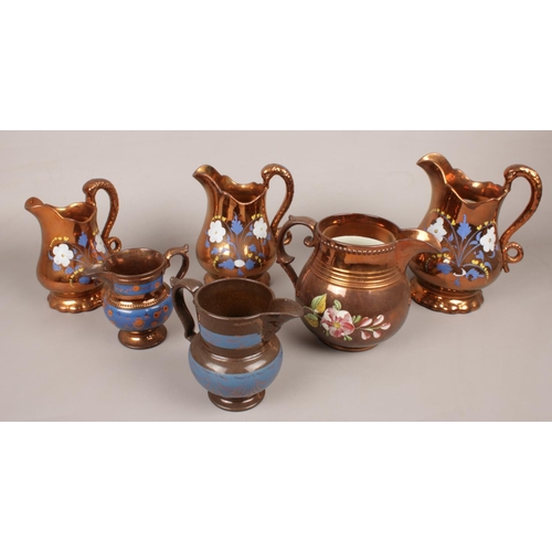 72 - A quantity of copper lustre jugs. Including set of 3 graduated examples, etc.