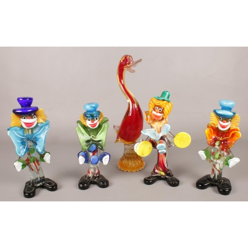 73 - Four murano glass clowns along with a similar duck example.