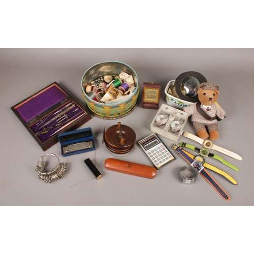 82 - A box of collectables. Includes wooden fishing reel, quartz wristwatches, sewing equipment, baromete... 