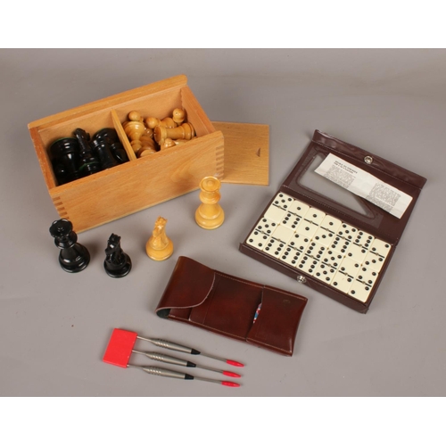 83 - A boxed set of weighted chess pieces, along with darts and dominoes.