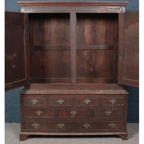 599 - A period oak linen press with raised fielded panel doors.