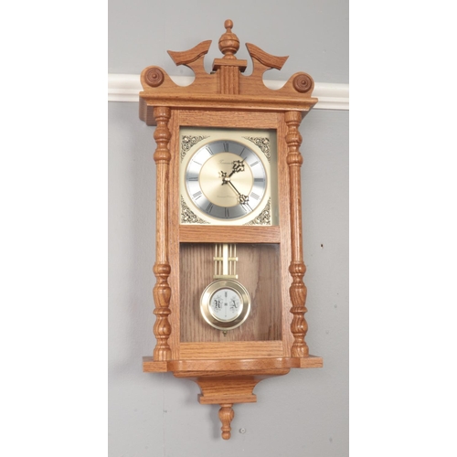368 - A modern oak Timemaster quartz wall clock. Westminster Whittington chiming.