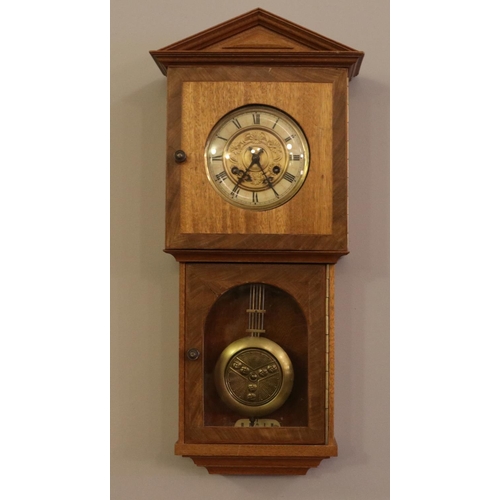 394 - A Oak cased pendulum wall clock. (68cm height, 23cm width)