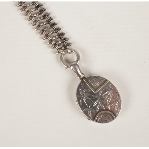 415 - A Victorian white metal locket and chain.