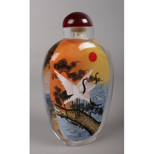 460 - A Chinese glass snuff bottle, reverse painted with a landscape scene and cranes.