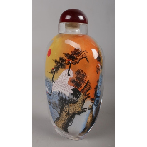 460 - A Chinese glass snuff bottle, reverse painted with a landscape scene and cranes.