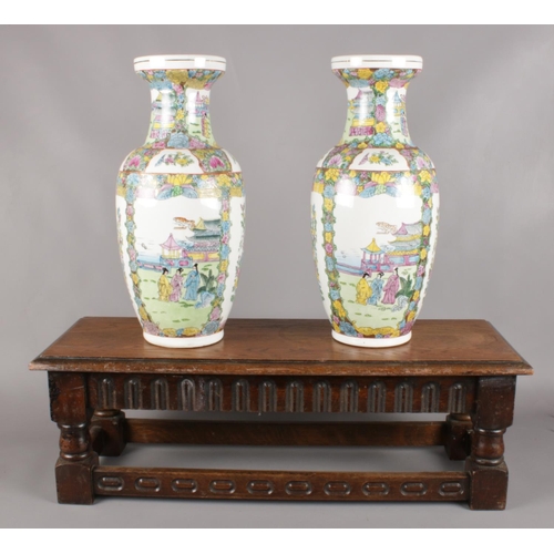 64 - A pair of decorative oriental vases, with carved oak stool. (Vase height 44.5cm).