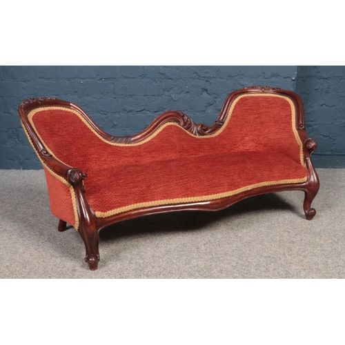 526 - An upholstered child's two seat sofa with carved mahogany frame. (Height 47cm, Length 113cm).